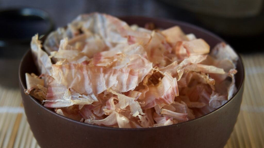 Bonito flakes in brown bowl on bamboo roller