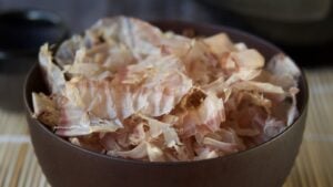 Bonito flakes in brown bowl on bamboo roller