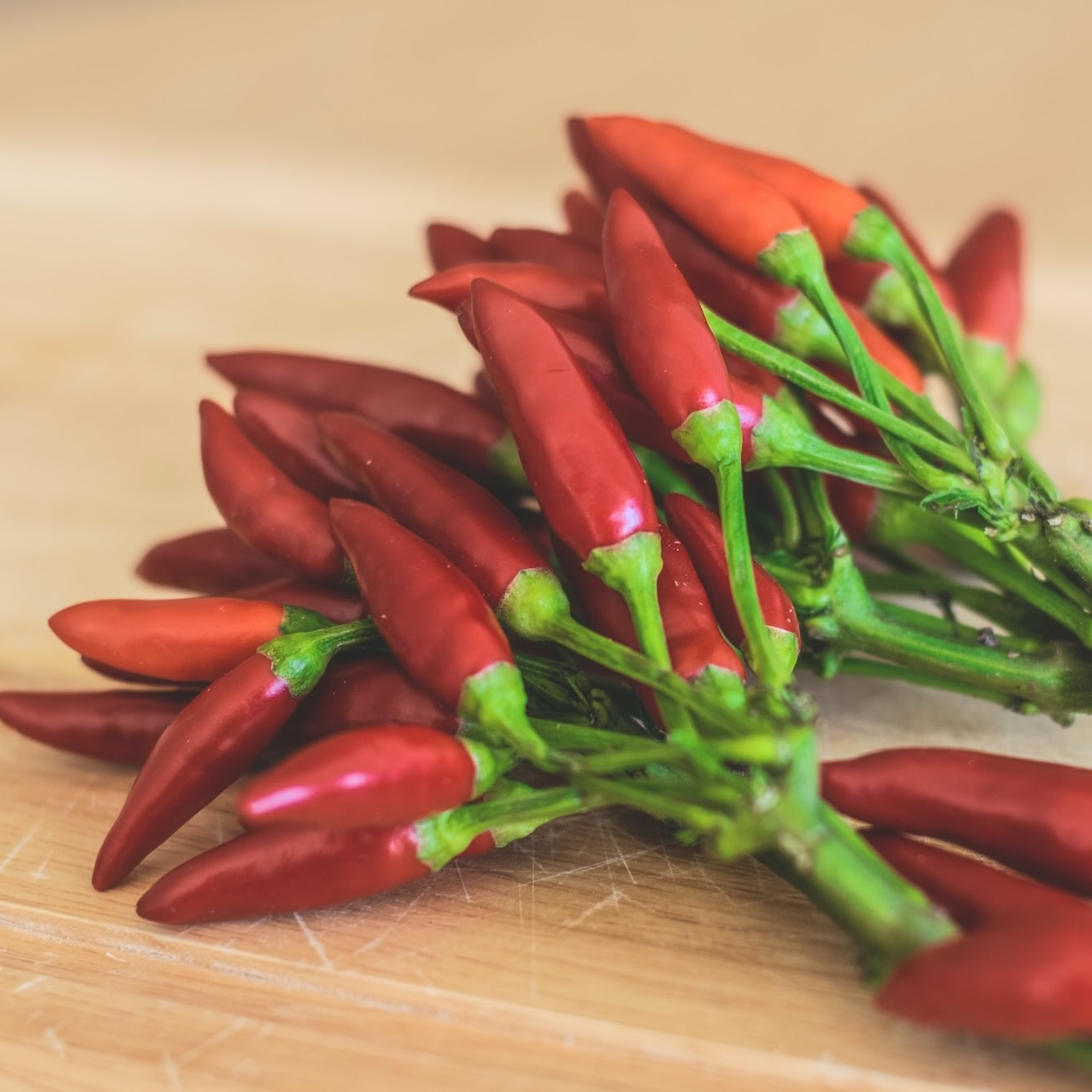Red chili peppers on wooden table Red chili peppers on wooden table