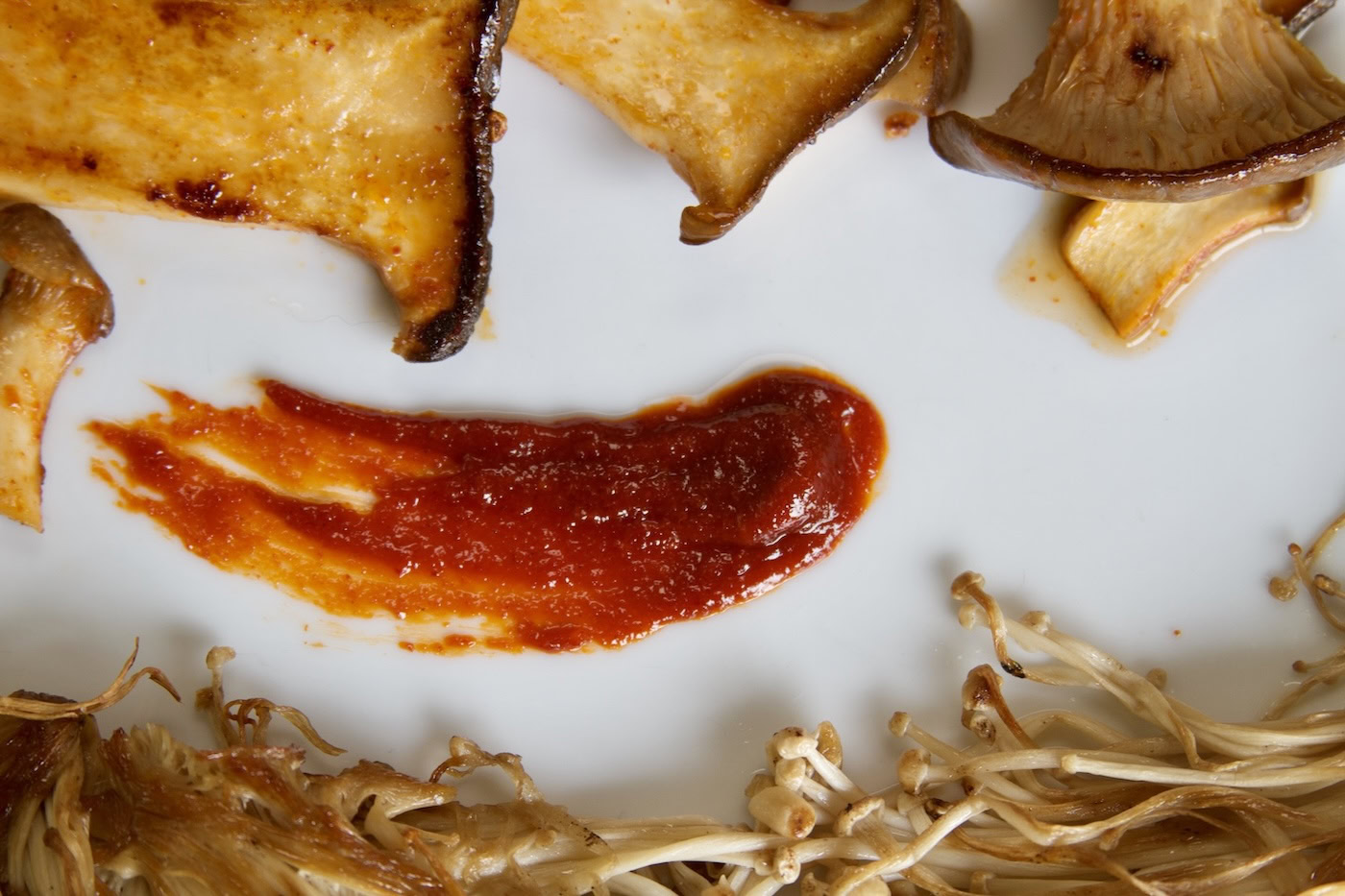 Gochujang smeared on plate with mushrooms