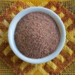 Kala namak in white bowl on colorful fabric