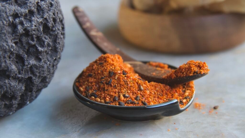 Shichimi togarashi in black dish with curved spoon
