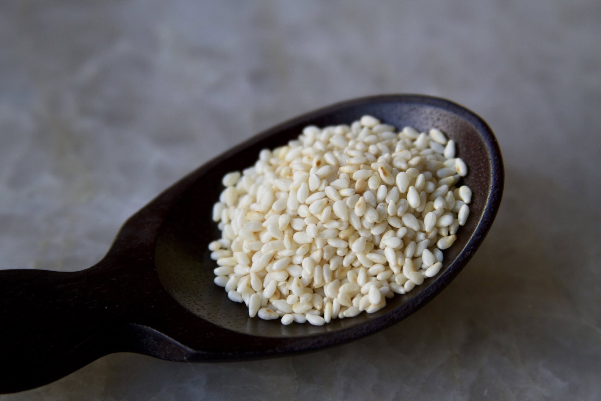 White sesame seed in wooden spoon