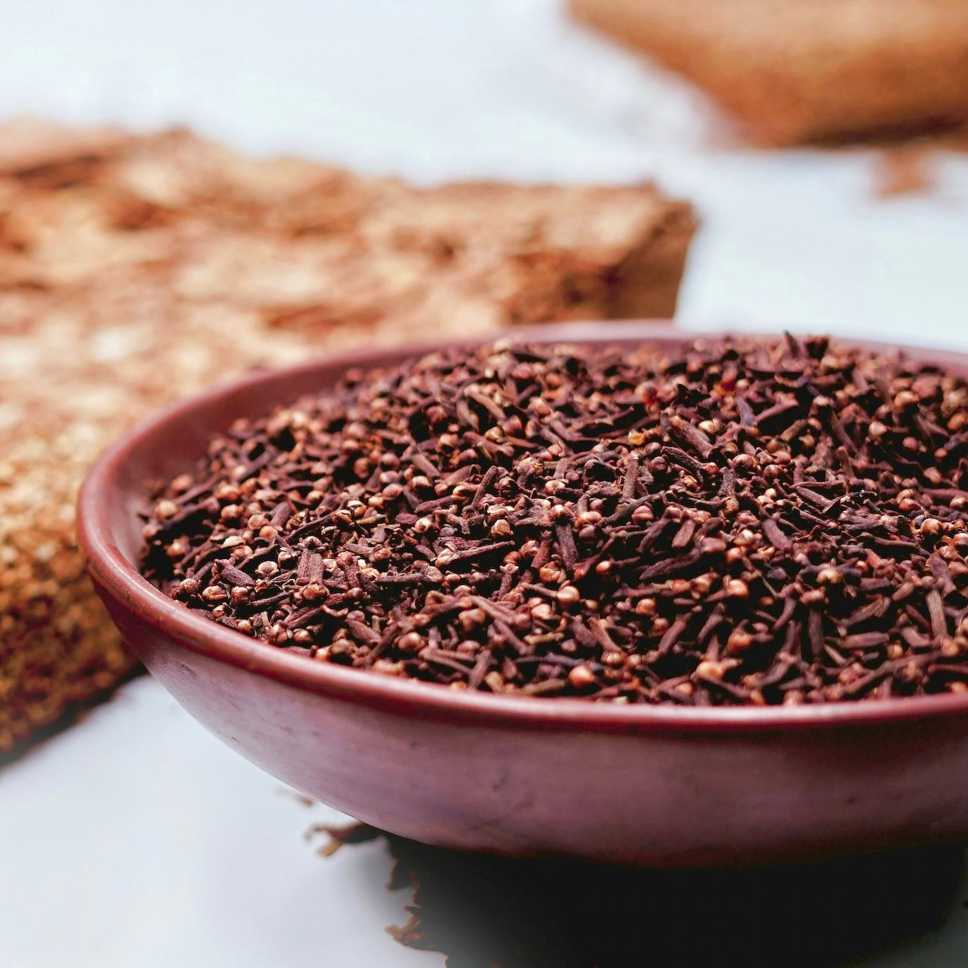 Whole cloves in maroon bowl