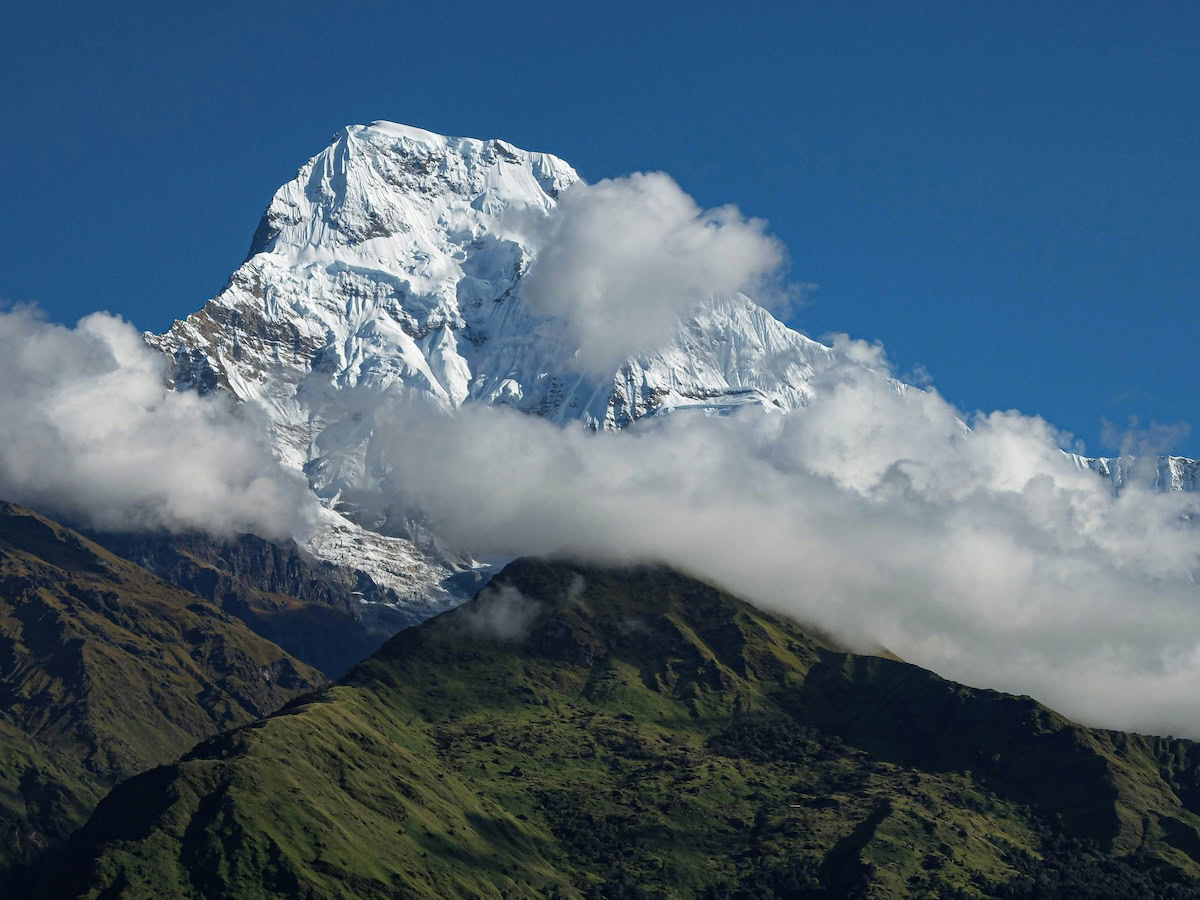 A peak of Anapurna, the Himalayas—a large mountain with a cloud covered peak