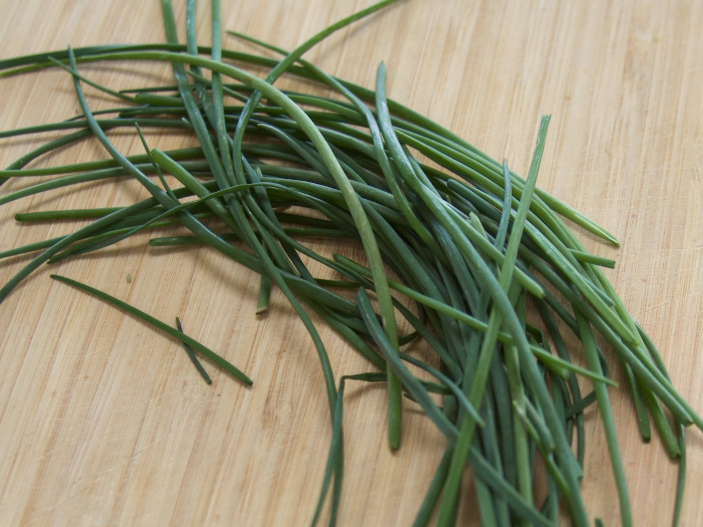 Chives on wooden cutting board