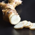 Sliced galangal close-up on a black plate