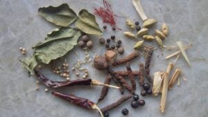 Spice assortment on quartz: chiles, cardamom, fennel seed, corianders, long pepper, juniper berries, peppercorns, saffron