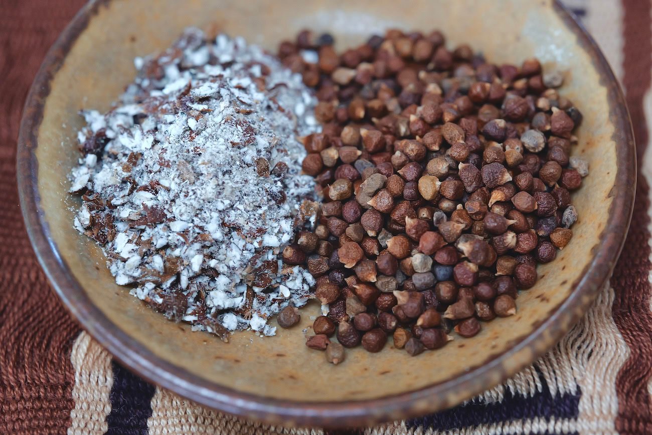 Grains of paradise, whole and ground in an artsy brown bowl