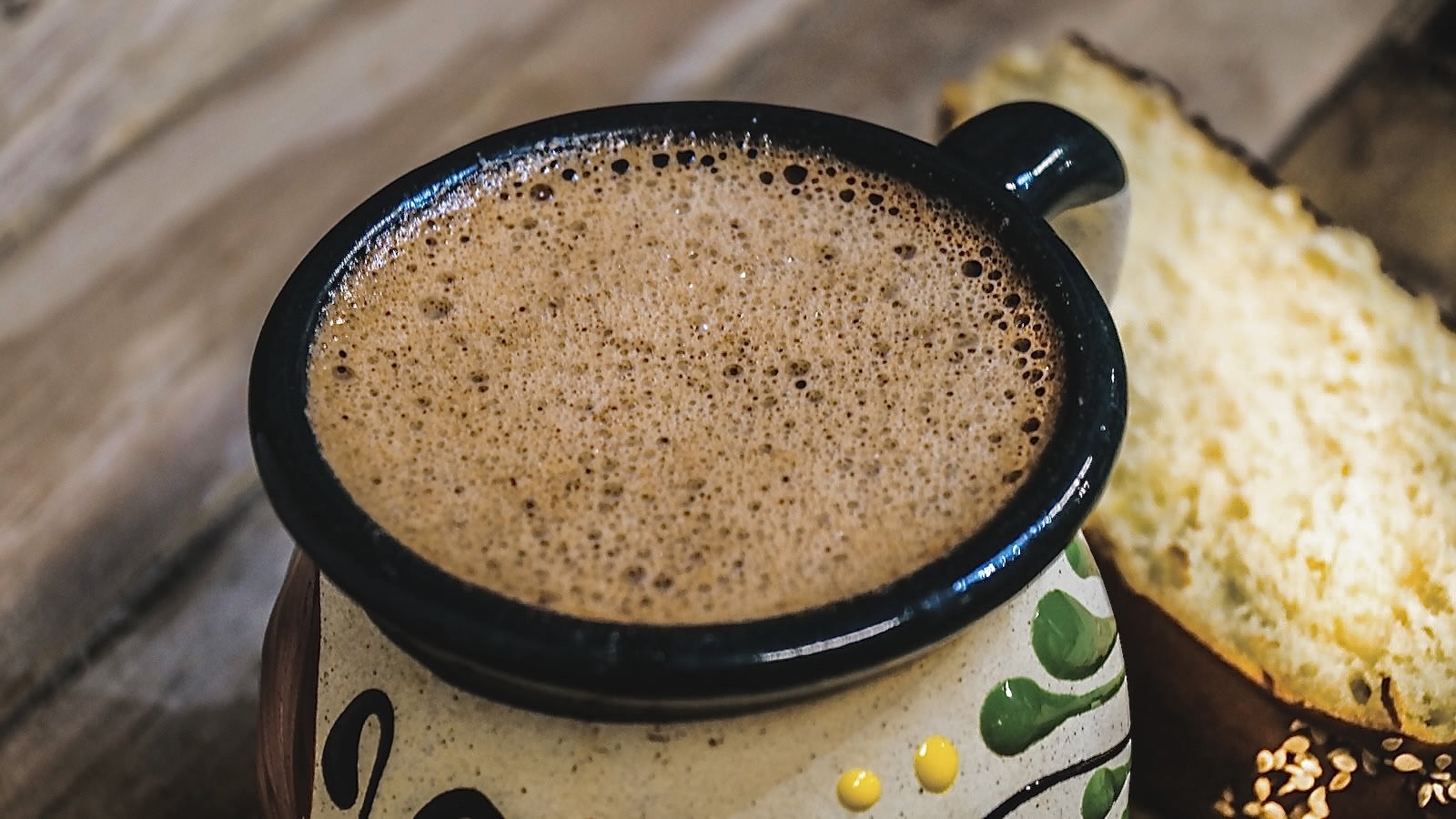 Mexican hot chocolate with sweet bread on wooden table