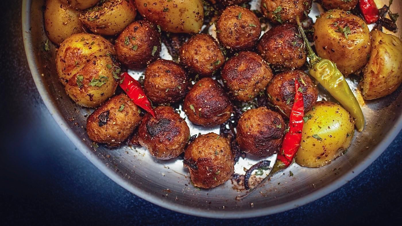 Swedish meatballs, potatoes, and chilis in a pan