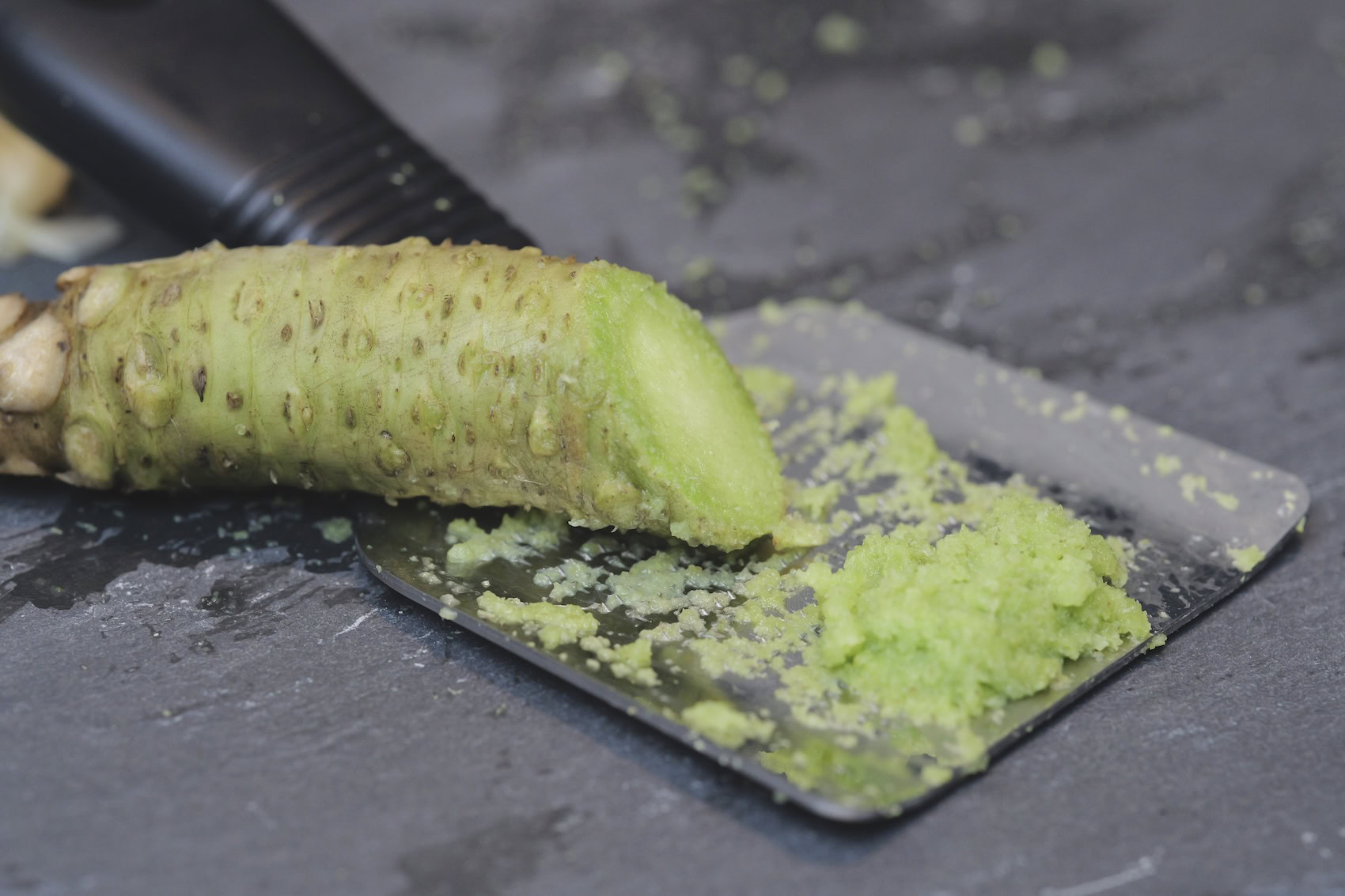 Freshly grated wasabi rhizome on stone plate