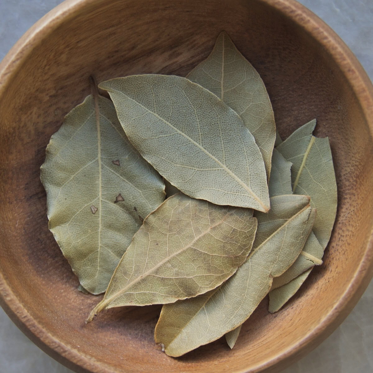 Bay leaves in a wooden bowl, close-up