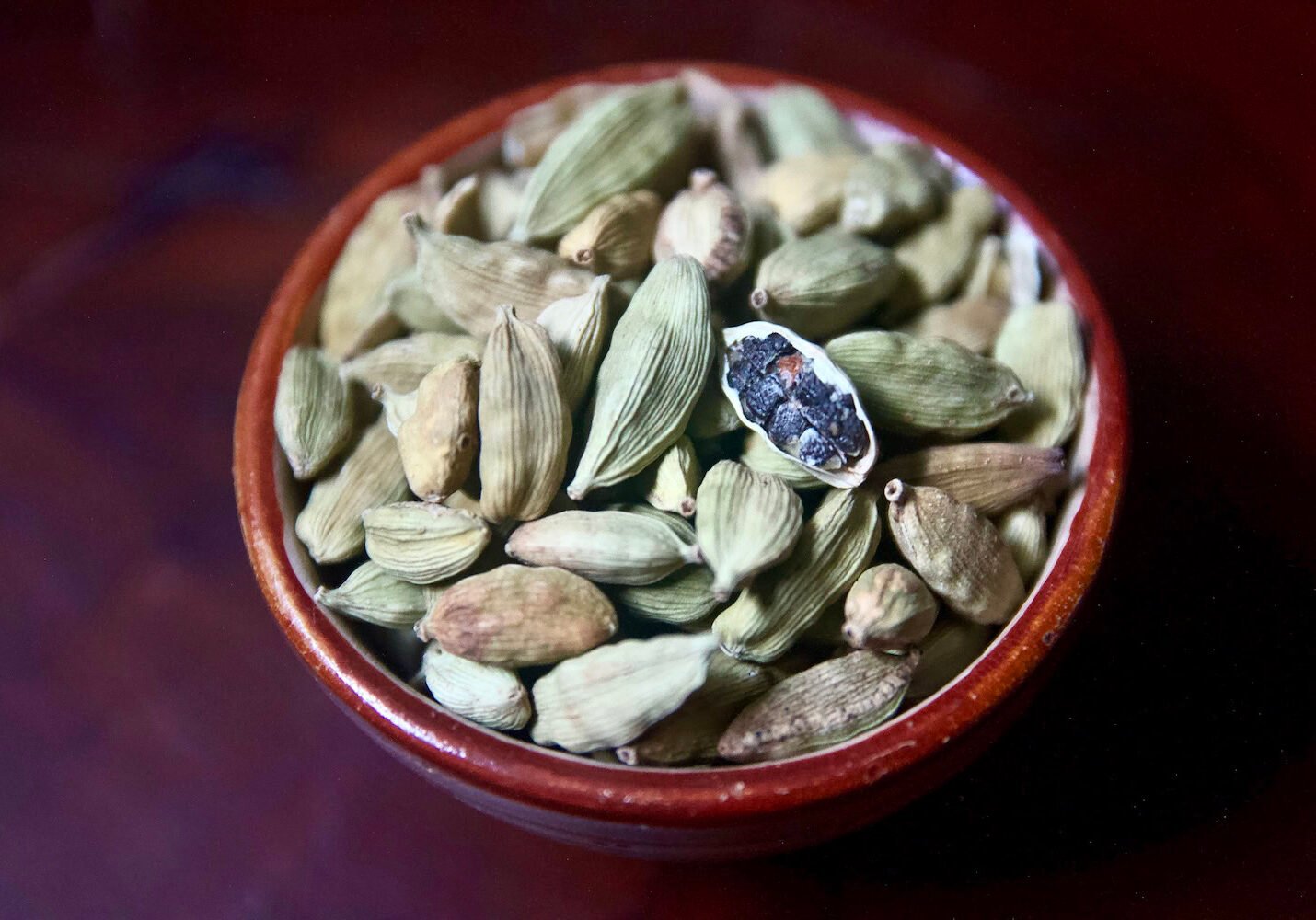 Cardamom pods in ceramic bowl Cardamom pods in ceramic bowl