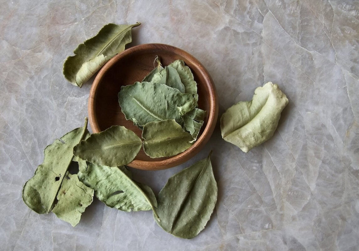 Dried makrut lime leaves on quartz