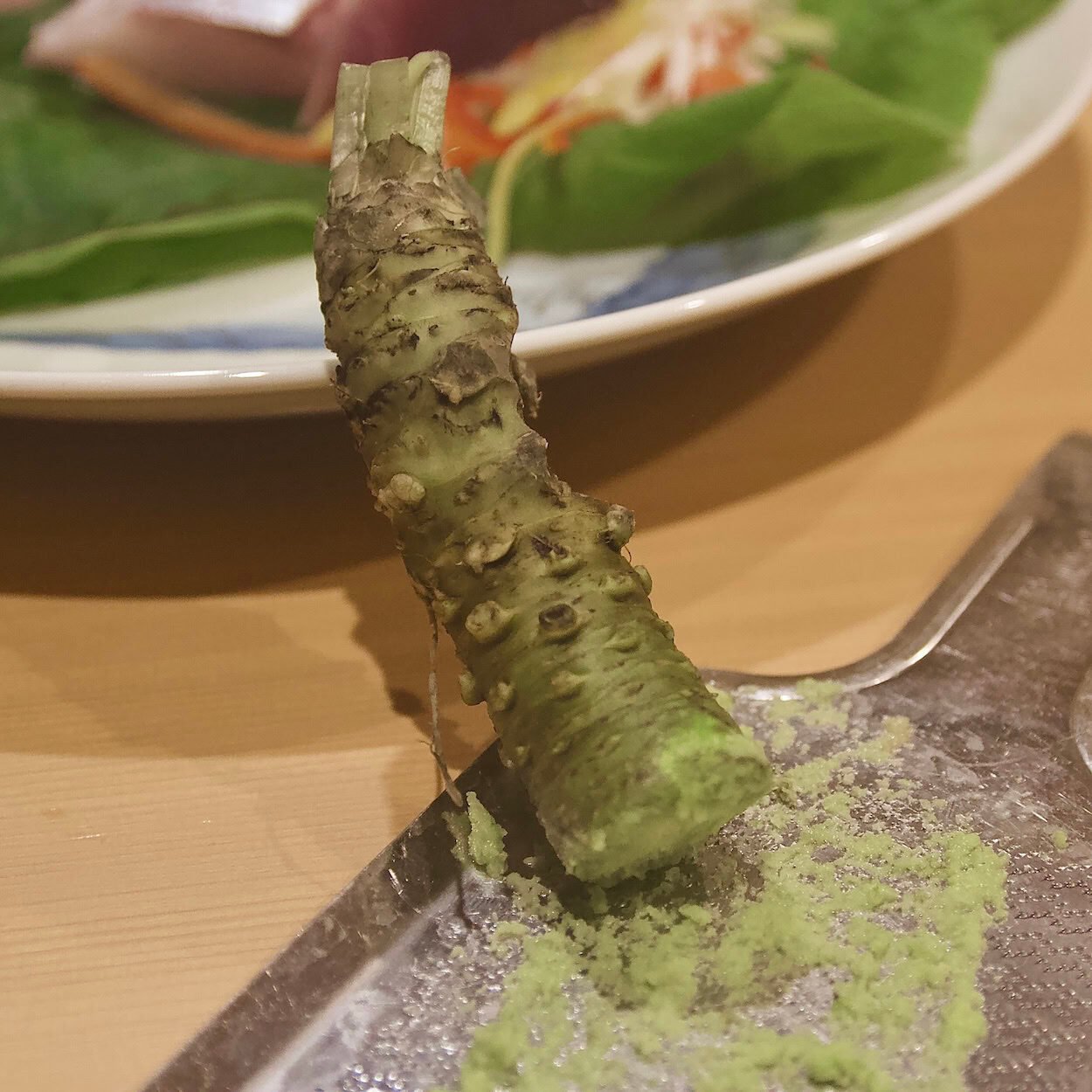 Freshly grated wasabi rhizome next to dish