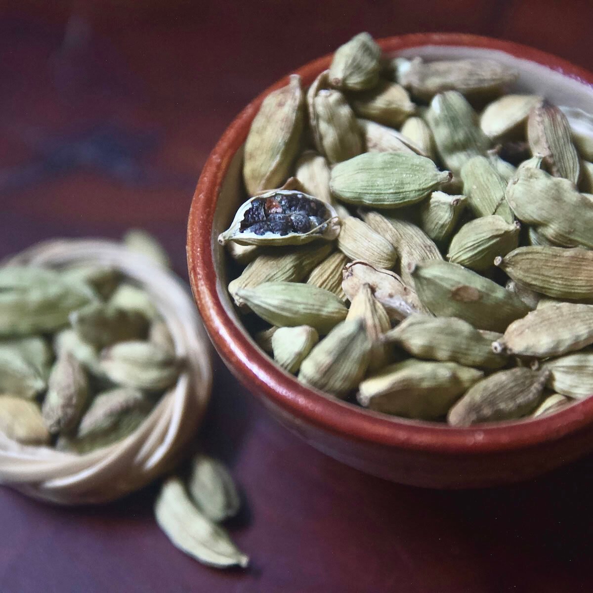 True cardamom in a bowl with one open pod True cardamom in a bowl with one open pod